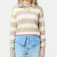 A person wears the Guest in Residence Collegiate Stripe Polo—pink and yellow stripes—over a blue collared shirt and light-wash jeans, standing against a plain background.