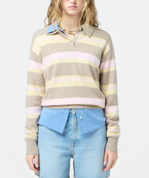 A person wears the Guest in Residence Collegiate Stripe Polo—pink and yellow stripes—over a blue collared shirt and light-wash jeans, standing against a plain background.