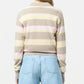 A person wearing the Guest in Residence Collegiate Stripe Polo in beige, pink, and yellow with light blue jeans, shown from the back against a plain background.