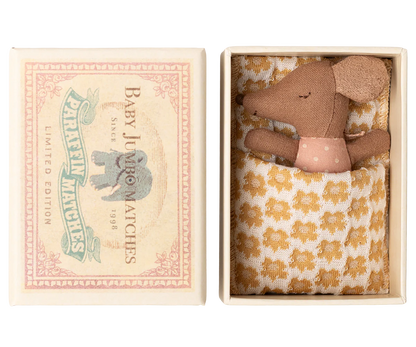 The Maileg Sleepy Wakey Baby Mouse in Matchbox - Rose features a small mouse in a pink polka dot outfit, tucked under a cozy blanket inside a matchbox-style box.