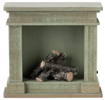 The Maileg Fireplace, Miniature - Dusty Green features a vintage finish and four faux birch logs inside—an ideal touch of charm for any miniature home.