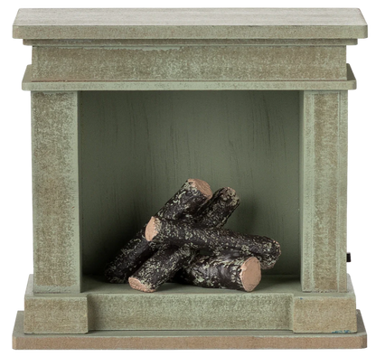 The Maileg Fireplace, Miniature - Dusty Green features a vintage finish and four faux birch logs inside—an ideal touch of charm for any miniature home.