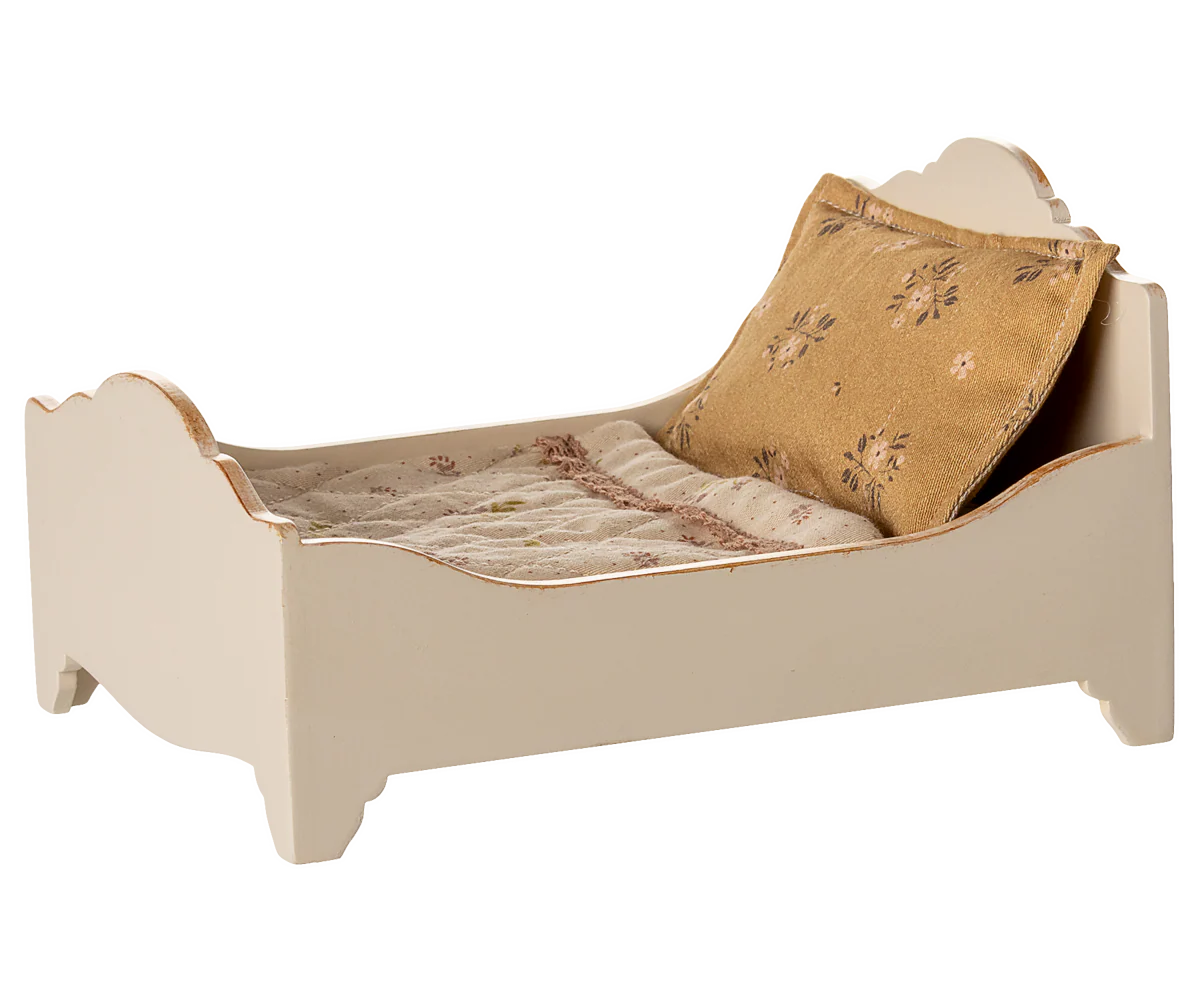 The Maileg Bed, Mouse - Off White is a small, cream-colored wooden bed with a patterned pillow and blanket, perfect as a cozy sleeping spot for mice.