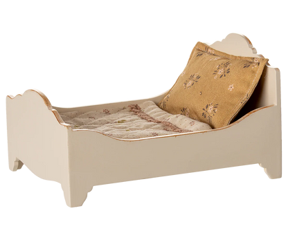 The Maileg Bed, Mouse - Off White is a small, cream-colored wooden bed with a patterned pillow and blanket, perfect as a cozy sleeping spot for mice.