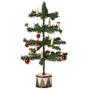 The Maileg Christmas Tree, Mouse is a small artificial tree with red baubles, candle-shaped ornaments, and mushrooms, set in a round white base decorated with black triangles.