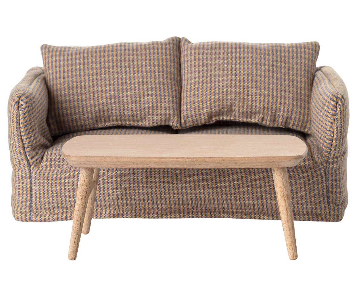 The Maileg Coffee Table, Mouse - Nature is a simple wooden table with four legs, set in front of a small checkered sofa with two cushions—ideal for a mouse-sized space.