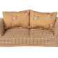 The Maileg Couch, Mouse – Mable is a small, soft sofa with a checkered beige pattern and two floral tan cushions, perfect for cozying up in your Mouse hole Farmhouse.