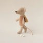 Maileg Fairy Mouse, Little - Rose stands upright with a soft pink dress, delicate wings, a long tail, and is accessorized with a small yellow backpack and a brown vest, plus a tag attached to its hand.