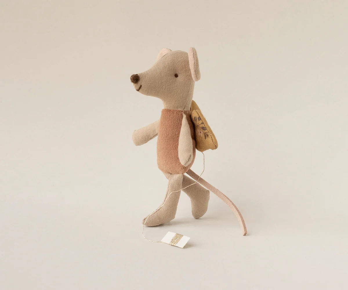 Maileg Fairy Mouse, Little - Rose stands upright with a soft pink dress, delicate wings, a long tail, and is accessorized with a small yellow backpack and a brown vest, plus a tag attached to its hand.