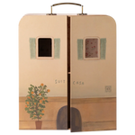 A whimsical Maileg SuitCasa suitcase, designed to resemble a charming house facade with two windows, green shutters, a potted plant, and partially open doors revealing a floral interior—perfect for welcoming Little Sister and Brother Mouse and their collection of miniature furniture.