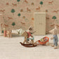 Two toy mice play in a miniature room; one rides a rocker, the other pushes a cart of macarons. The Maileg Vintage Floor Lamp, Mouse - Sand adds soft light, complementing the animal and rainbow wallpaper.