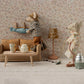 Two toy mice from Maileg tidy their miniature living room; one vacuums while the other hangs laundry. The cozy scene features the Maileg Couch, Mouse - Mable, a table with tea set, and a lamp.