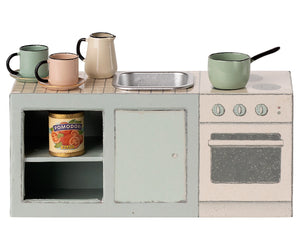 Kitchen Counter - Mouse by Maileg: this charming toy kitchen set features a stove, oven, sink, shelves, mugs, pot, pan, and a can of tomatoes on a light-colored background—perfect for creating delightful mouse-approved meals.