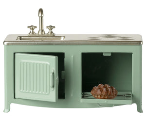 A miniature Mint Kitchen - Mouse set by Maileg, featuring a green metal stove and sink, with an open toy oven door revealing a tiny pie inside—perfect for the Mouse Hole Farmhouse.