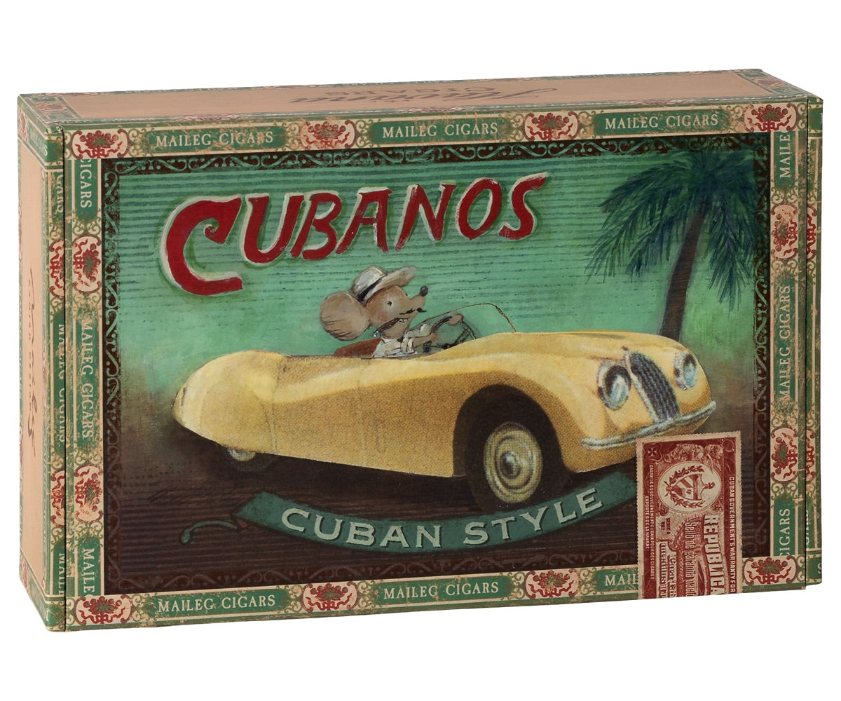 Maileg’s "Grandma and Grandpa Mice in Cigarbox" comes in a rectangular box adorned with charming artwork of the two mice driving a yellow convertible beneath a palm tree—a playful scene that invites grandmice (and their families) to dream up tropical adventures from the comfort of their cozy cigarbox bed.