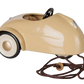 The Maileg Car, Mouse - Wheat is a beige metal car featuring a black steering wheel, white wheels, and a pull string attached to the front—perfect as a pull-along toy or for imaginative play with toy mice, shown against a plain background.