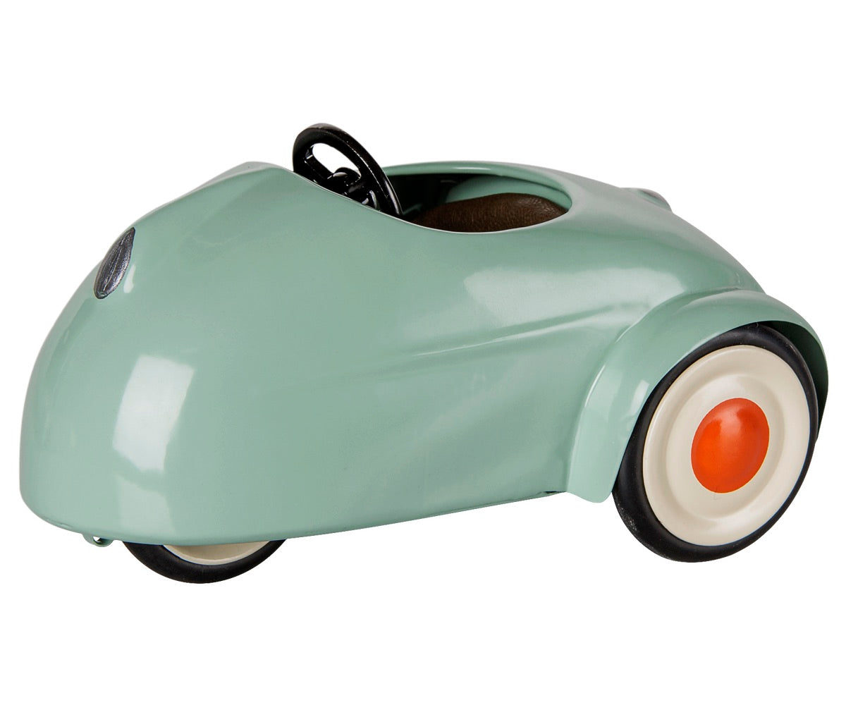A Light Mint Car - Mouse by Maileg, featuring a minimalist design in mint green metal with white wheels and orange hubcaps, is displayed on a white background.