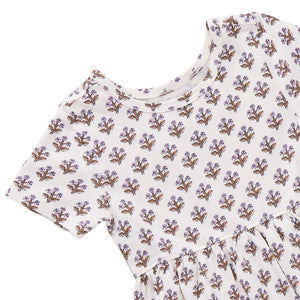 Girls’ Sunny Dress by Coop Kids PC: A short-sleeve cream dress with a round neckline, adorned with an all-over small purple and brown floral print. Made from organic Pima cotton, this versatile piece delivers comfort and easy style for any occasion.
