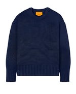 The Guest in Residence Cozy Crew Cashmere Sweater in dark blue showcases a cozy design with a round neckline, along with ribbed hem and cuffs. A gold label can be found on the inside collar.