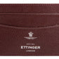 The Capra Flat Credit Card Case by Ettinger is a minimalist brown goat leather holder with two card slots, embossed with a crown emblem and "Ettinger London" in white, ideal for the discerning individual.