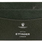 The minimalist design of the Capra Flat Credit Card Case in green goat leather by Ettinger features an embossed logo and "Ettinger London" text on the front.