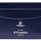 Close-up of a blue goat leather Capra Flat Credit Card Case by Ettinger, featuring multiple slots and "Ettinger London, ESTD 1934" in white logo text, highlighting its minimalist design.