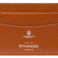 The Capra Flat Credit Card Case by Ettinger is crafted from brown goat leather and features a minimalist design with two slots. "ETTINGER LONDON ESTD 1934" is beautifully embossed in white, adding an elegant and timeless touch.
