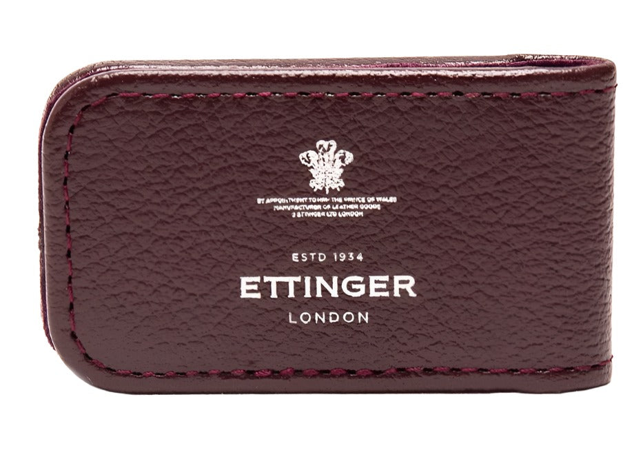 The Ettinger Capra Magnetic Cash Clip, a luxurious burgundy accessory from Ettinger, is exquisitely crafted from premium goat leather and features an embossed text and logo, combining elegance with functionality.