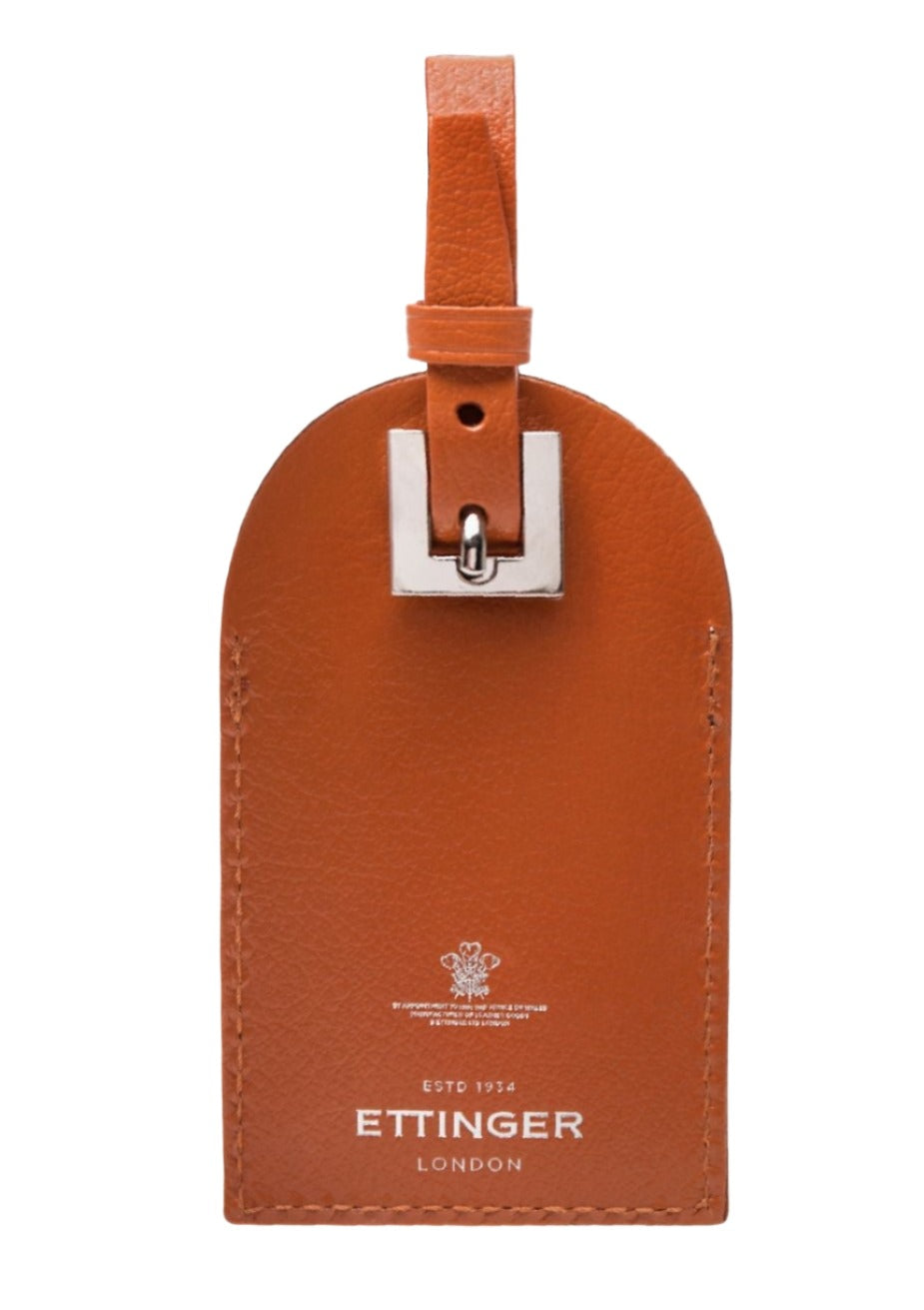 Brown goat leather luggage tag from the Capra Collection, featuring a buckle strap and "Ettinger" embossed at the bottom with a logo above.