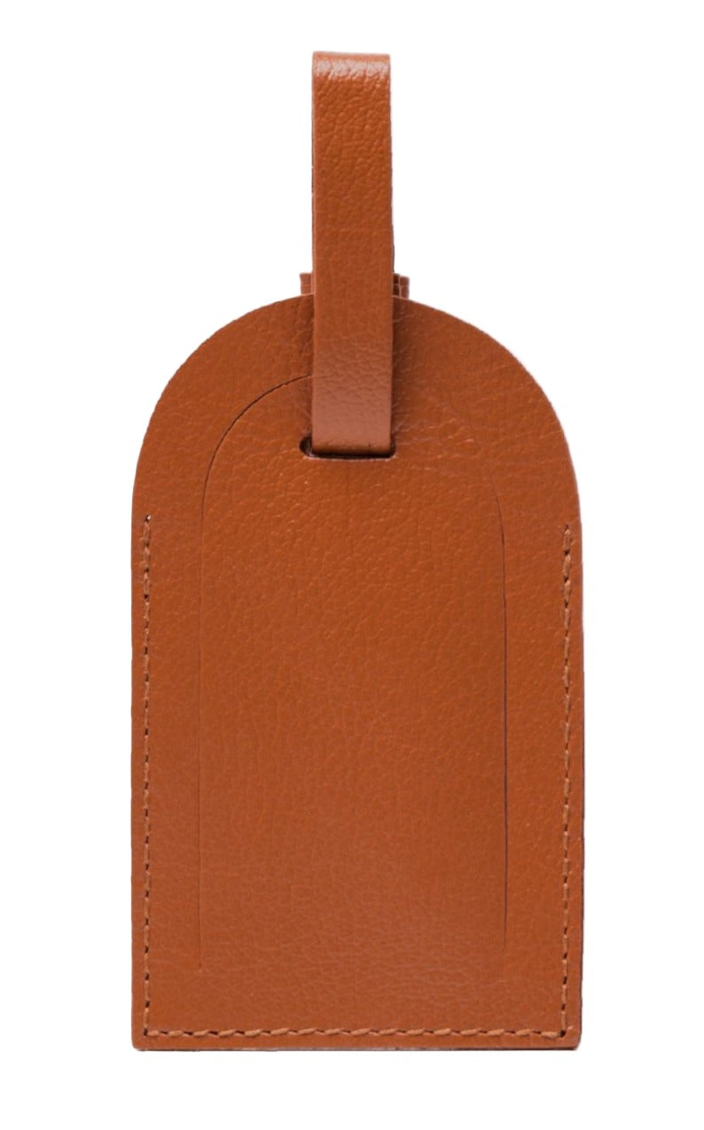 This Capra Luggage Tag with Security Flap by Ettinger is crafted from brown goat leather and features a sturdy strap, combining durability with elegance.