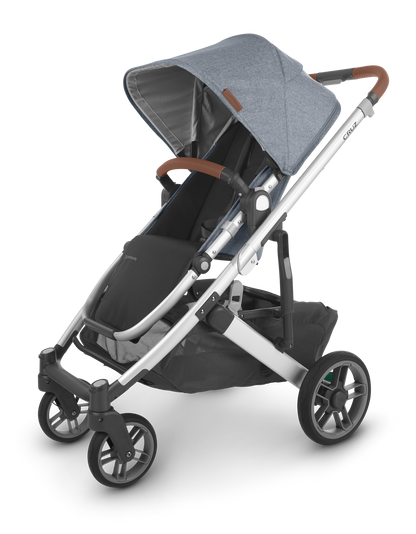 The UPPAbaby Cruz V2 Stroller, in grey, includes a canopy, adjustable handlebar, and a storage basket underneath, along with a convenient toddler seat.