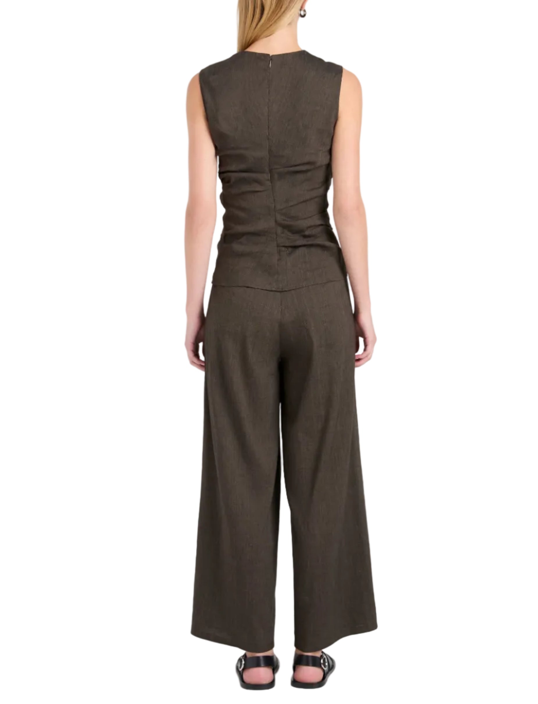 A person stands with their back to the camera, wearing a sleeveless brown top and the Proenza Schouler White Label Calla Slub Linen Pant with black sandals, highlighting the pant’s relaxed, cropped silhouette.