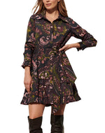 A woman wearing the Figue Cami Dress, a dark floral cotton poplin piece with long sleeves and a ruffled hem, paired with tall black boots.