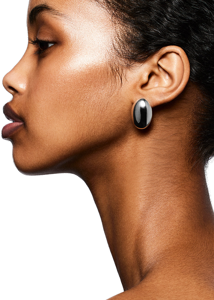 Profile of a person wearing the eye-catching LIÉ STUDIO Camille Earrings, crafted from 925 sterling silver and featuring black accents, against a white background.