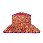 The Island Capri Hat by Lorna Murray is a pink and yellow woven sun hat featuring a wide, pleated brim with a zigzag edge and UPF 50+ protection—ideal for travel—shown against a white background.