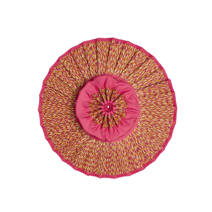 Round decorative pillow with layered pink and multicolored fabric, featuring a textured and gathered design with a central button accent—perfect for adding a playful pop of color to your space or complementing your favorite Lorna Murray Island Capri Hat during travel, viewed from above on a white background.