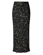 Altuzarra Casey Skirt in black, featuring a streamlined silhouette and slim fit with an all-over small floral print in green, yellow, and light blue tones.