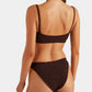 A woman with a braid is shown from the back wearing the Hunza G Cassie Bikini in dark brown, featuring a textured design and classic coverage, set against a plain white background.