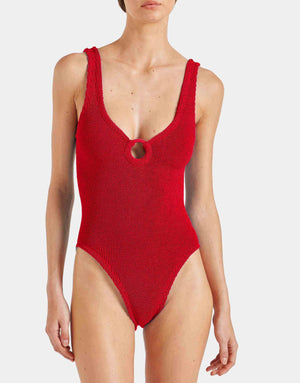 A person wearing the Hunza G Celine Tonal Hoop Swim, a red one-piece with crinkle fabric and a front keyhole cutout, photographed against a plain background.