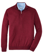 Peter Millar Autumn Crest Quarter-Zip sweater in a classic fit, in burgundy Merino wool, paired with a light blue shirt underneath.