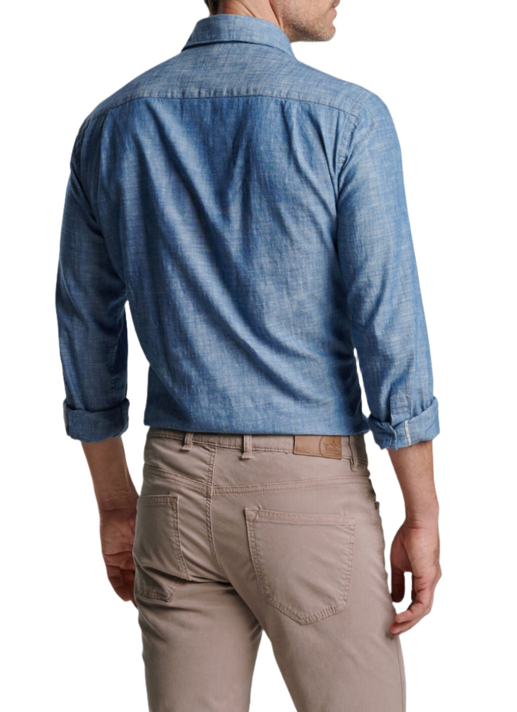 A man is standing with his back to the camera, wearing a Peter Millar Japanese Selvedge Sport Shirt and beige pants.