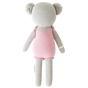 Meet Claire the Koala by Cuddle + Kind, a 20" grey knitted stuffed animal with two round ears and a pink dress, shown from behind—ready for magical treetop adventures or cozy treehouse secrets.