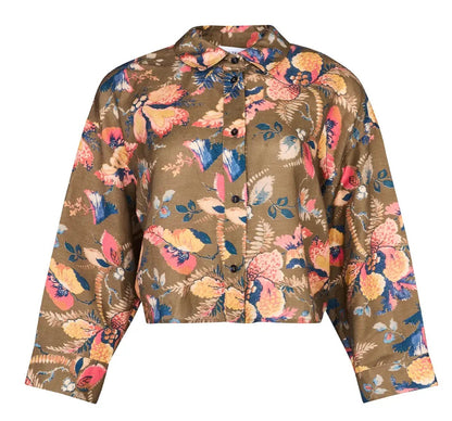 The Clarke Shirt by Hunter Bell NYC is a brown oversized cropped shirt with a colorful floral pattern in pink, yellow, navy, and cream. It features long sleeves, a collar, and a modern boxy fit.