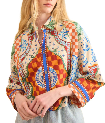 A person wearing the Clarke Shirt by Hunter Bell NYC, featuring a modern boxy fit with colorful, intricate checks, floral, and geometric designs, paired with light blue jeans.