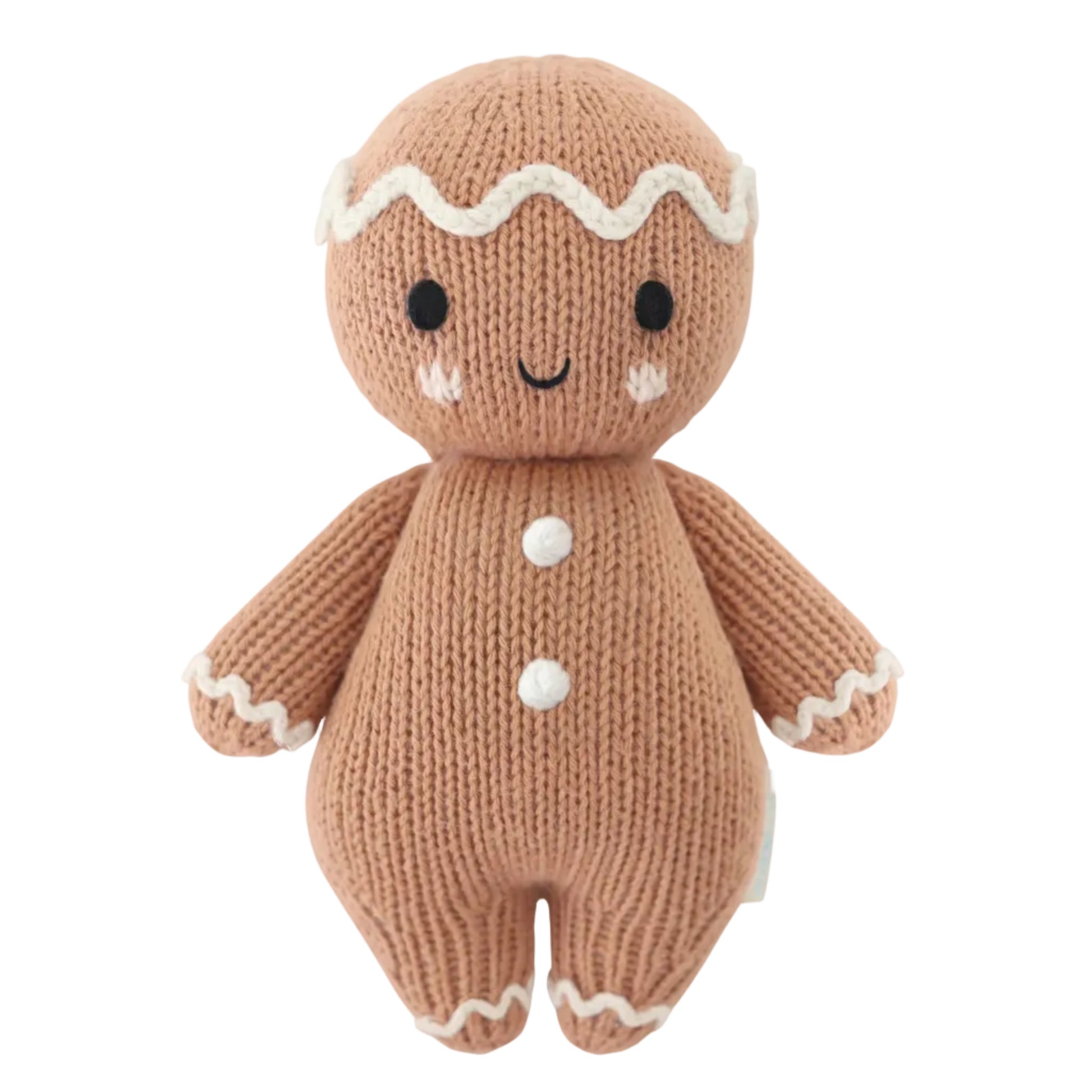 Introducing the Baby Gingerbread - Icing White from Cuddle + Kind—a charming knitted doll featuring a smiling face, white icing details on its head, arms, and legs, and two white buttons on its body. Lovingly handcrafted from soft cotton yarn, this delightful companion is perfect for little ones.