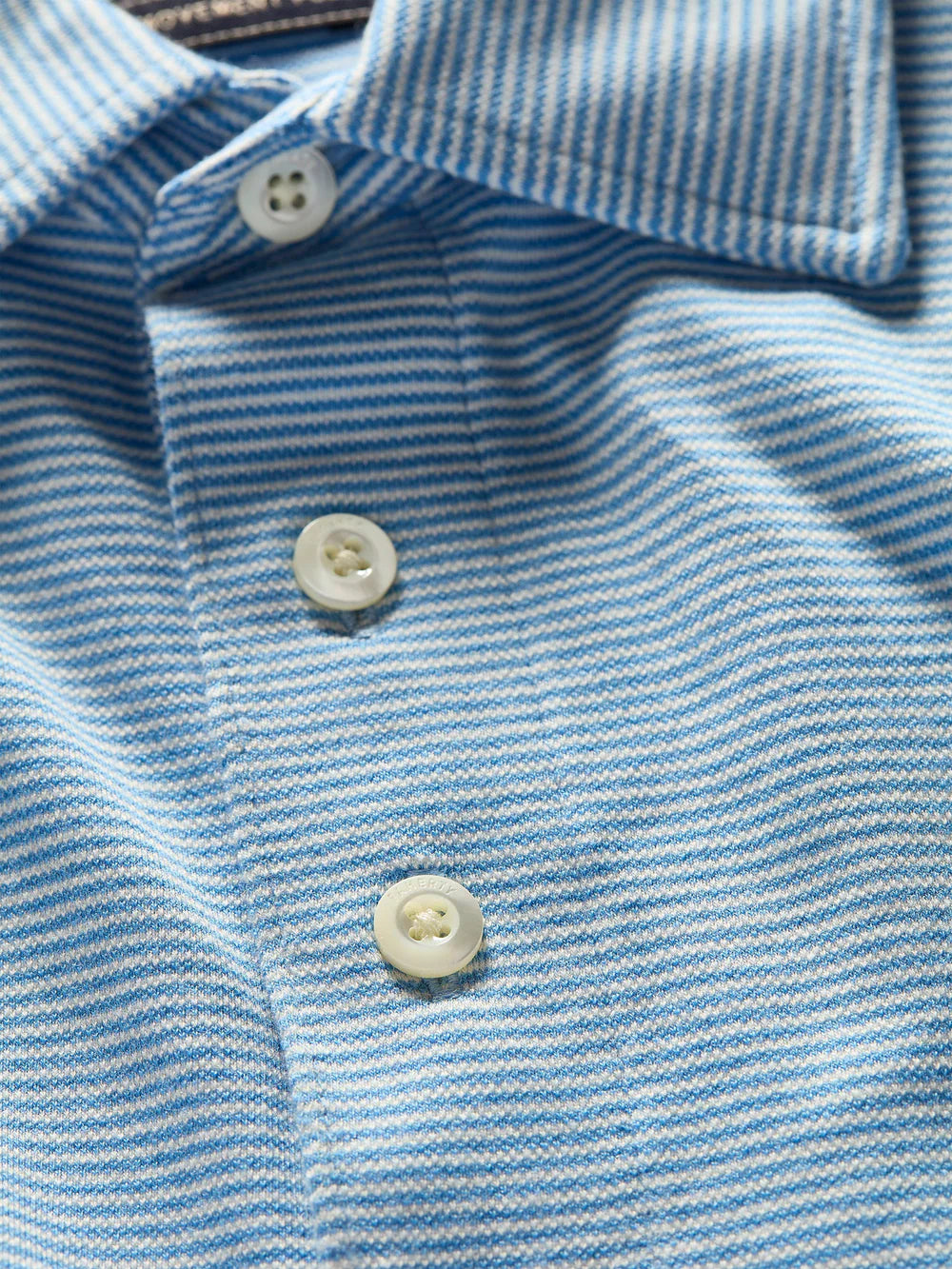 Here's an alternative version of the sentence using the product data:

The Faherty Movement Long-Sleeve Pique Polo, in a classic fit and light blue striped design, features a buttoned placket with three white buttons and a vented hem for enhanced comfort.