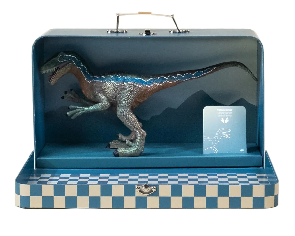 The Velociraptor Dinosaur in a Collectible Box by Coco Village is presented in a blue, checkered suitcase and comes with a small informational card inside—perfect for sparking prehistoric adventures.