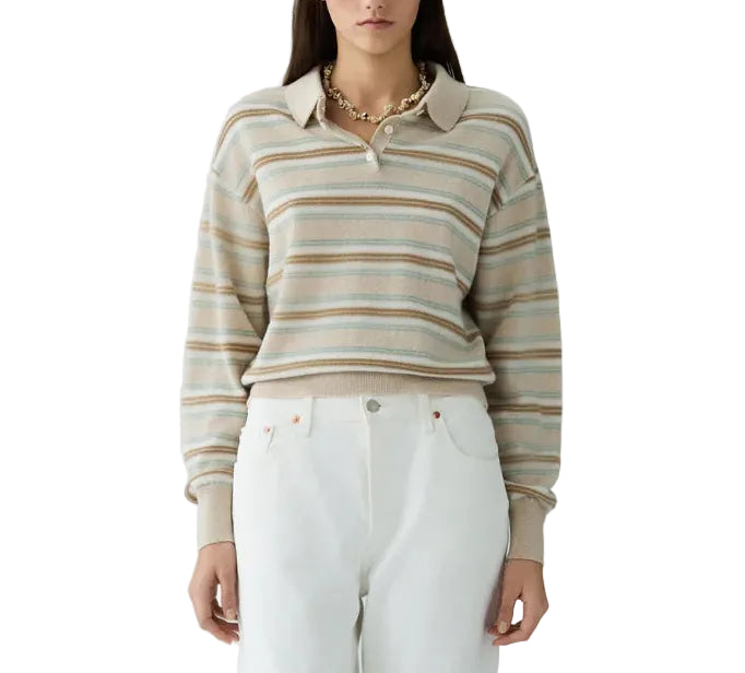 A woman stands facing forward, wearing the Guest in Residence Collegiate Stripe Polo tucked into high-waisted white pants.