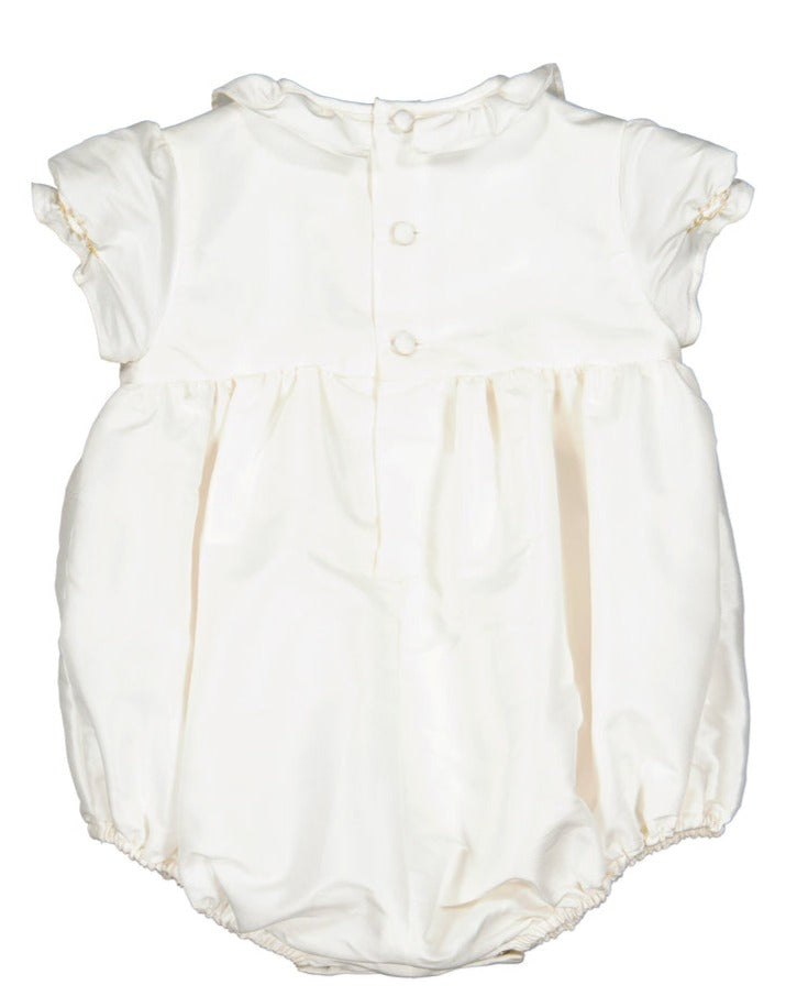 Antoinette White Silk Ceremony Baby Bubble with short sleeves, handmade smocked bubble front, and gathered waist on a plain background.