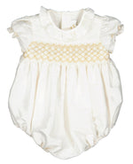 White Antoinette baby dress with short sleeves and decorative golden embroidery on the chest, isolated on a white background.